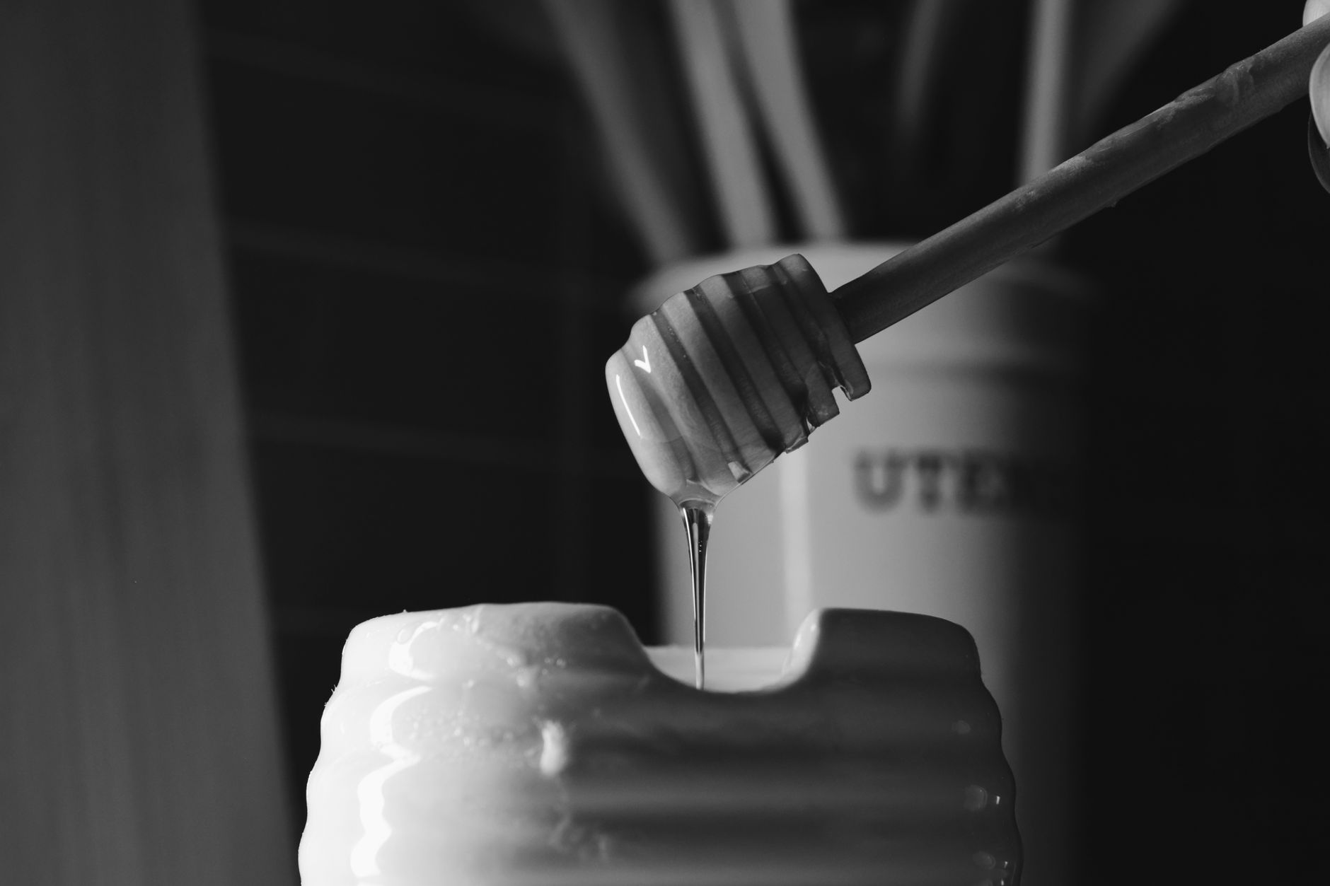 golden honey flowing from a Flow Hive tap into a glass jar